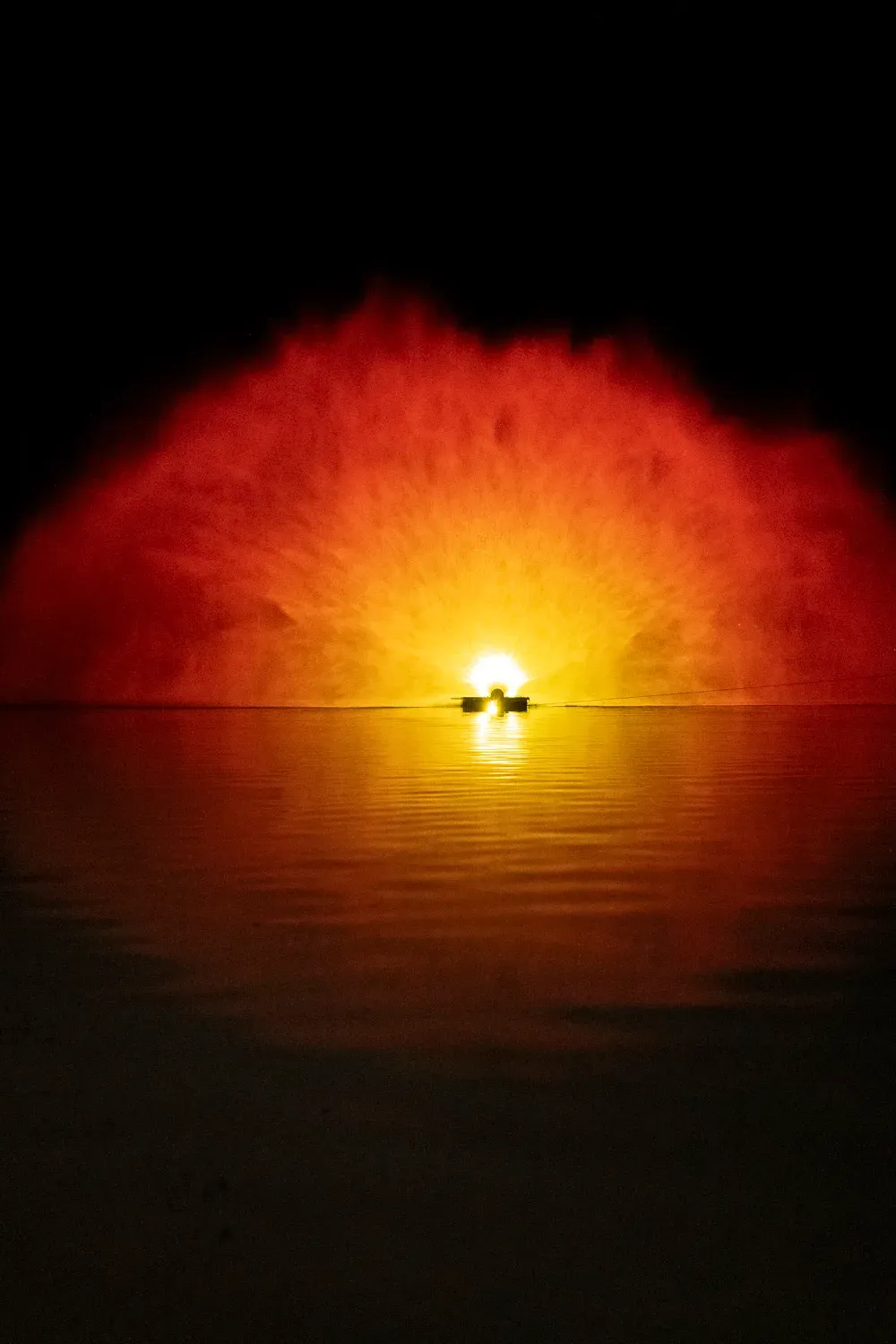 Lumière rouge et orange dans un nuage d’eau au-dessus du lac