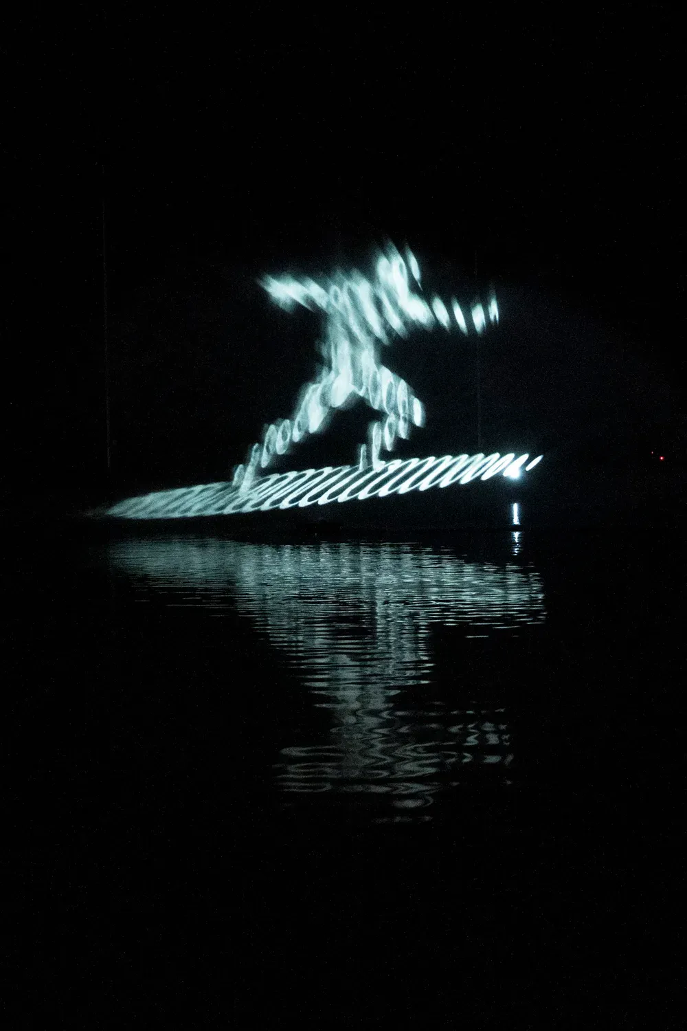 Un surfeur sur une vague de lumière, sur l’écran d’eau